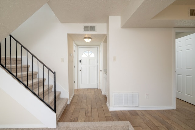 foyer entrance with a textured ceiling and hardwood / wood-style flooring