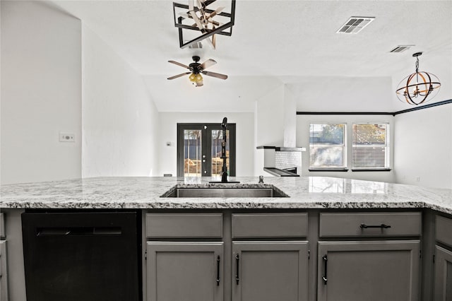 kitchen with ceiling fan with notable chandelier, black dishwasher, a textured ceiling, and a wealth of natural light