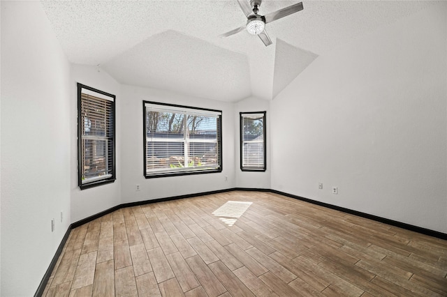 spare room with a textured ceiling, ceiling fan, and vaulted ceiling