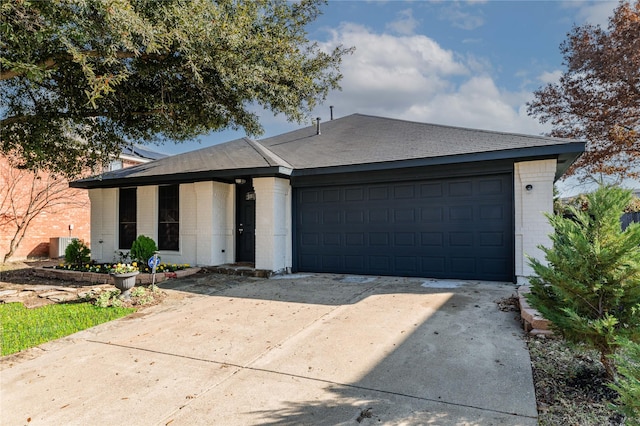 ranch-style home featuring central AC unit and a garage