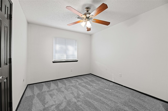 carpeted spare room featuring ceiling fan and a textured ceiling