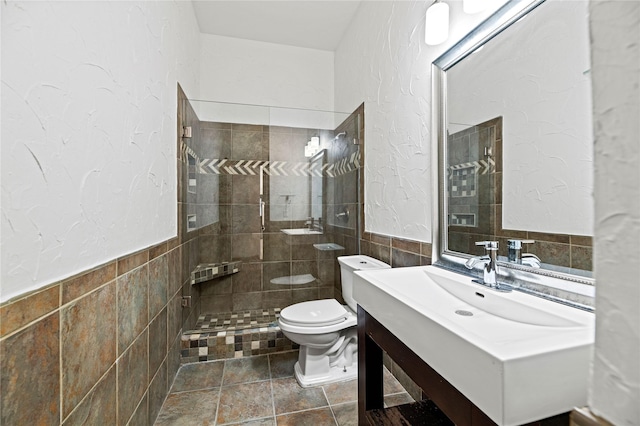 bathroom featuring tiled shower, vanity, tile walls, and toilet