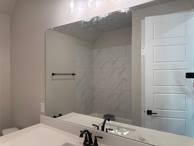 full bathroom featuring tiled shower / bath combo, vanity, and toilet