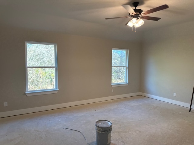 empty room with ceiling fan and plenty of natural light