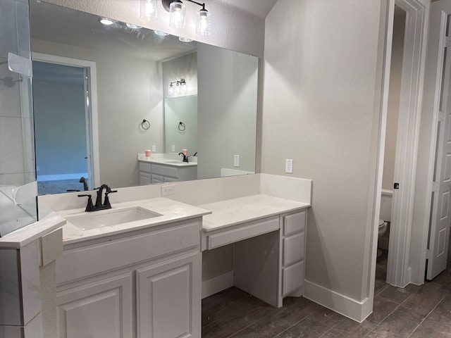 bathroom featuring vanity, wood-type flooring, and toilet