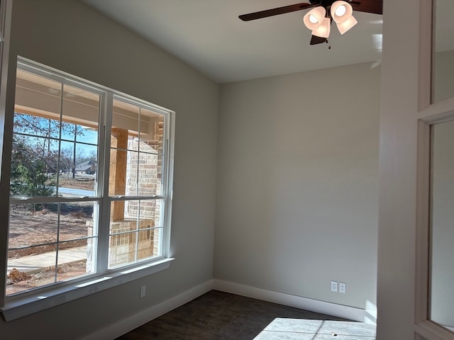 spare room featuring ceiling fan, a healthy amount of sunlight, and dark hardwood / wood-style floors