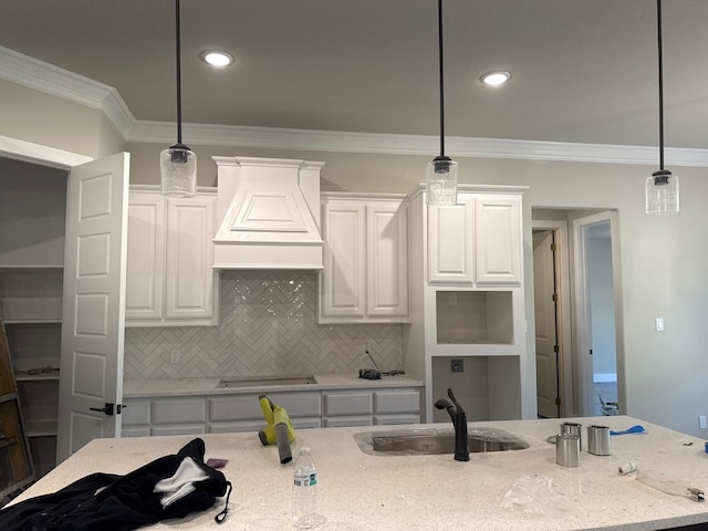 kitchen featuring premium range hood, light stone countertops, pendant lighting, and white cabinets