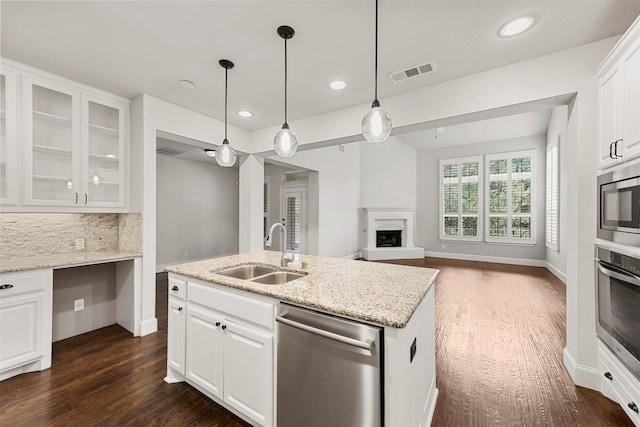 kitchen featuring dark hardwood / wood-style floors, sink, light stone countertops, white cabinetry, and appliances with stainless steel finishes