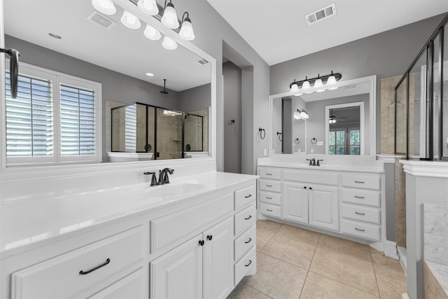 bathroom featuring vanity, a healthy amount of sunlight, walk in shower, and tile patterned floors