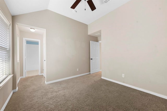 spare room featuring carpet, vaulted ceiling, and ceiling fan