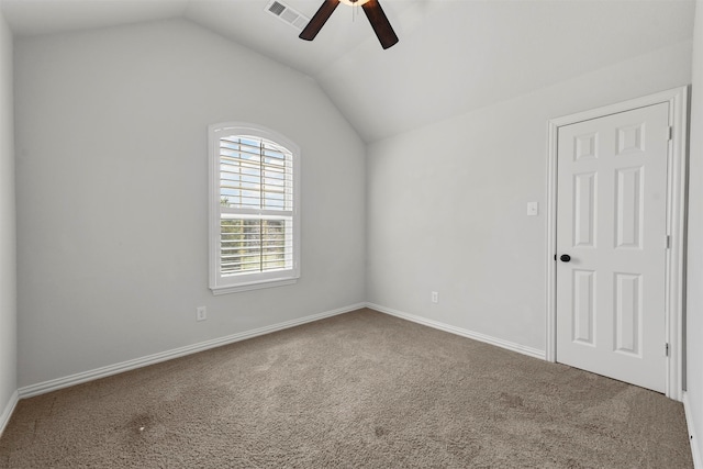 carpeted spare room with ceiling fan and vaulted ceiling