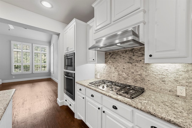 kitchen with backsplash, dark wood-type flooring, appliances with stainless steel finishes, and white cabinetry