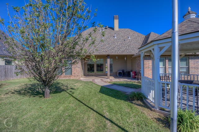 rear view of property featuring a patio and a lawn