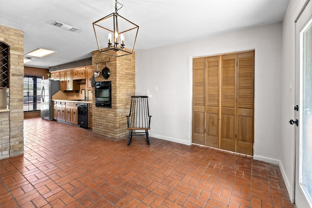 kitchen featuring dishwasher, hanging light fixtures, sink, an inviting chandelier, and stainless steel refrigerator