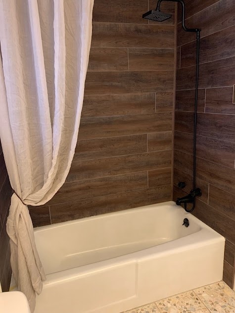 bathroom with shower / bath combo with shower curtain