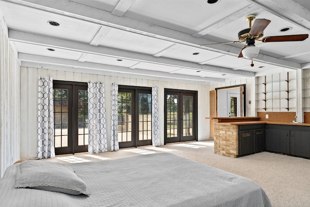 bedroom featuring beamed ceiling, french doors, light carpet, and access to outside