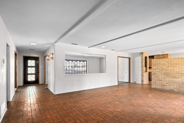 interior space featuring brick wall, plenty of natural light, and a fireplace