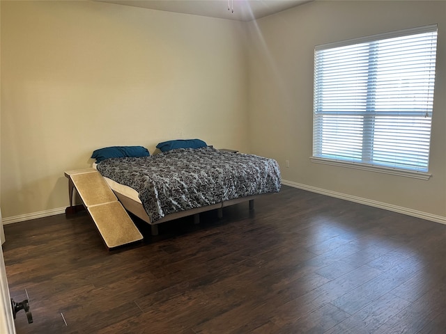 bedroom with dark hardwood / wood-style floors