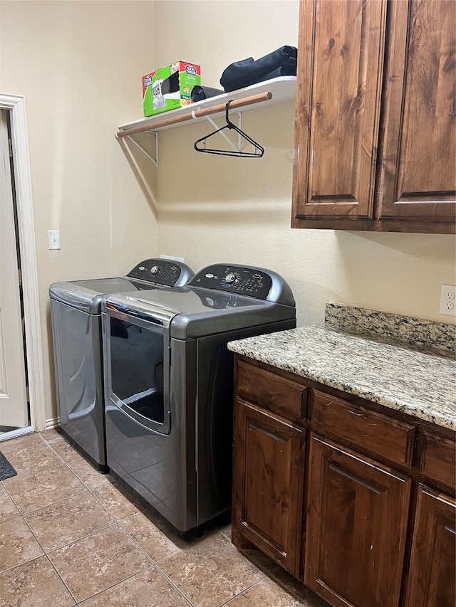 laundry room featuring separate washer and dryer and cabinets