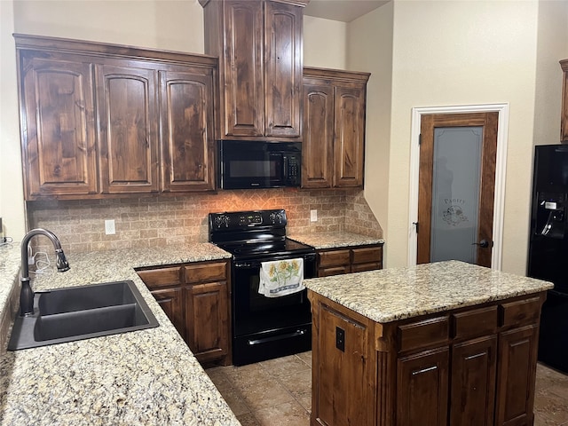 kitchen with sink, black appliances, light stone counters, and tasteful backsplash