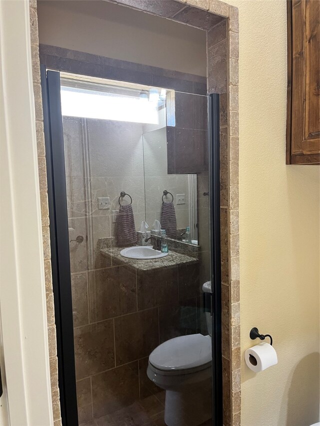 bathroom featuring toilet, curtained shower, and sink