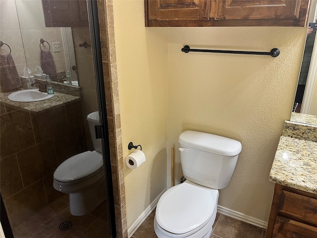 bathroom featuring vanity, tile patterned floors, toilet, and an enclosed shower