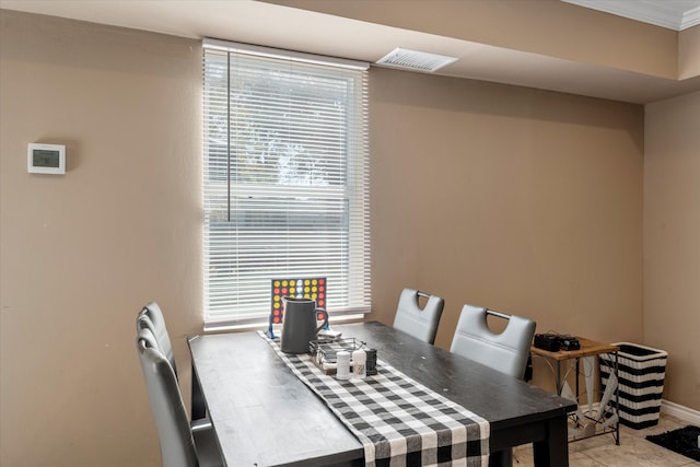 dining space featuring ornamental molding and plenty of natural light