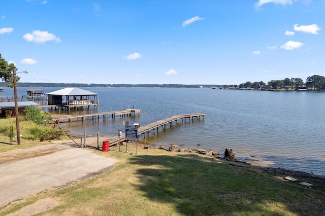 view of dock featuring a water view and a yard