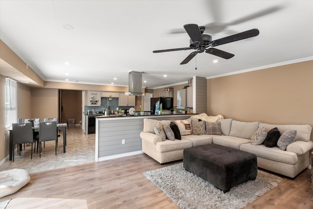 living room with ornamental molding, light wood-type flooring, and ceiling fan