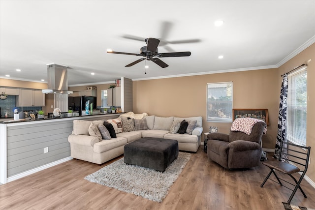 living room with light hardwood / wood-style floors, crown molding, and ceiling fan