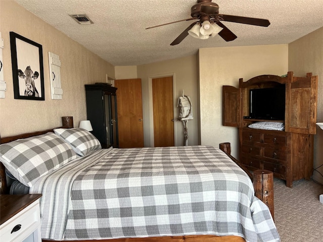 carpeted bedroom with a textured ceiling and ceiling fan