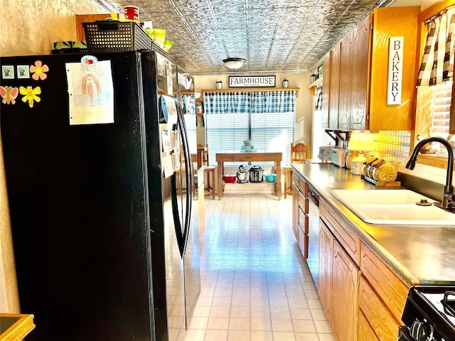 kitchen with light tile patterned flooring, black appliances, and sink