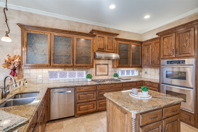 kitchen featuring hanging light fixtures, light stone countertops, ornamental molding, sink, and stainless steel appliances