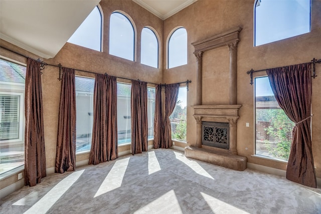 6809 Beckworth Ln, Plano, TX 75024 - unfurnished living room with carpet flooring, crown molding, a high ceiling, and a fireplace