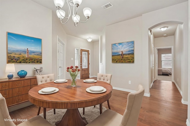 dining room with hardwood / wood-style flooring and a notable chandelier