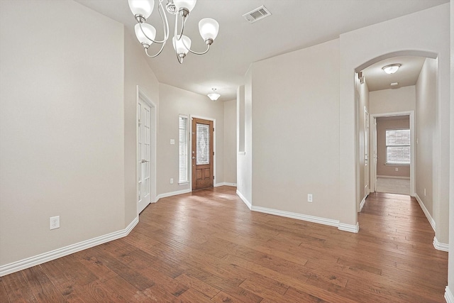 foyer entrance with hardwood / wood-style floors and an inviting chandelier