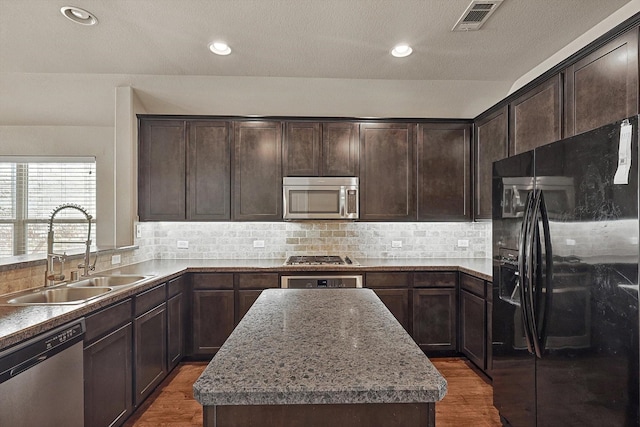 kitchen featuring dark hardwood / wood-style floors, a center island, sink, and stainless steel appliances