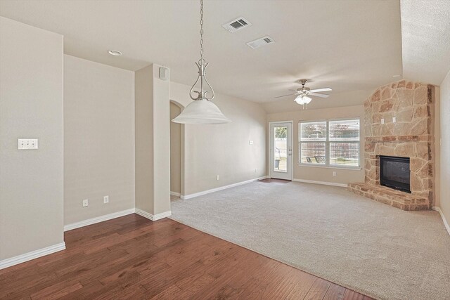 dining area featuring a stone fireplace, ceiling fan, and hardwood / wood-style flooring