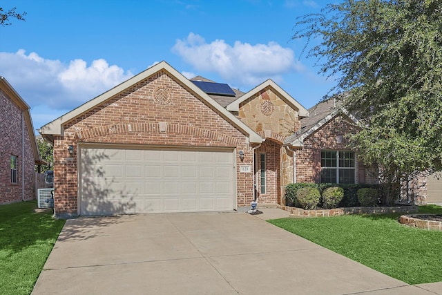 view of front property featuring a garage, a front yard, and solar panels