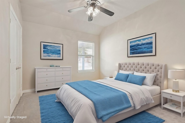 bedroom featuring ceiling fan, light carpet, and vaulted ceiling