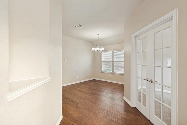 spare room with lofted ceiling, dark hardwood / wood-style floors, and a notable chandelier