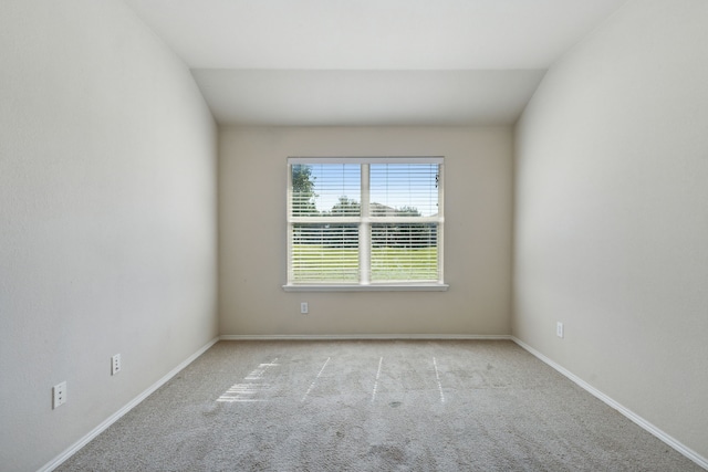 carpeted spare room with lofted ceiling