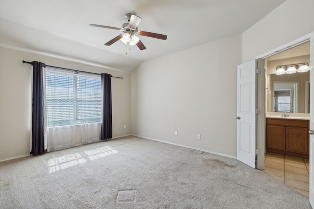 unfurnished room featuring sink, vaulted ceiling, light colored carpet, and ceiling fan