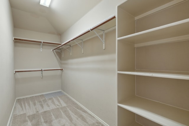 walk in closet featuring carpet and vaulted ceiling