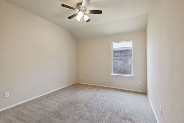 carpeted empty room featuring ceiling fan and vaulted ceiling