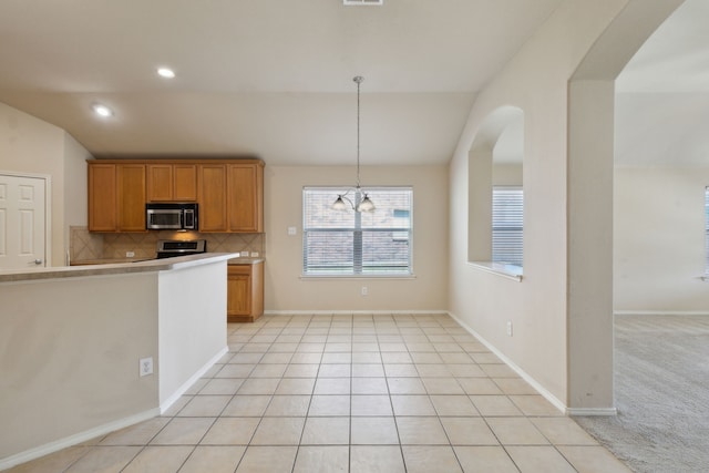 kitchen featuring a chandelier, stainless steel appliances, light tile patterned floors, and pendant lighting