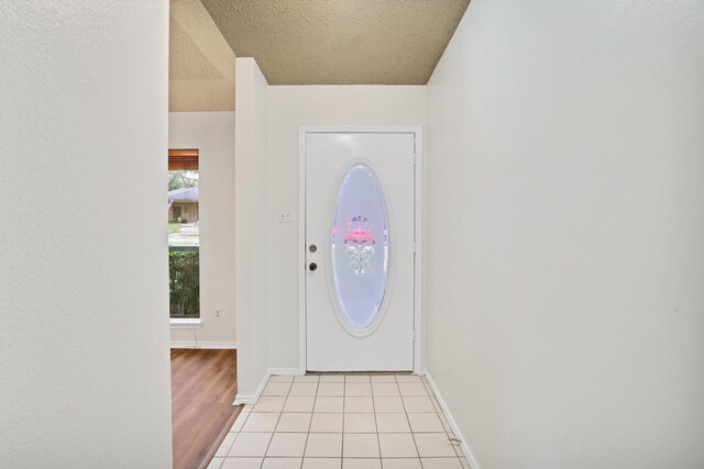 tiled foyer entrance featuring a textured ceiling