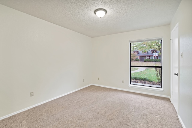 carpeted spare room featuring a textured ceiling