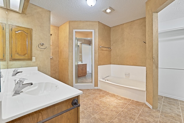 bathroom featuring vanity, tile patterned floors, independent shower and bath, and a textured ceiling