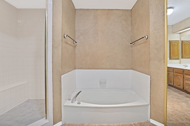 bathroom featuring vanity, shower with separate bathtub, and a textured ceiling